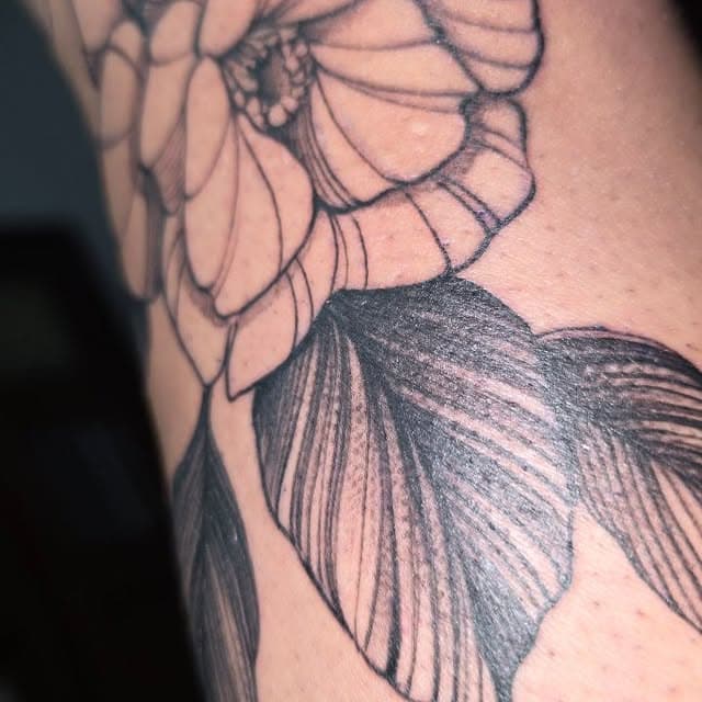 Detalle floral en tinta negra sobre piel